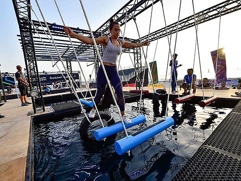 File picture of participants trying their hands at the Iron Grip obstacle during a media preview of a previous edition of Government Games at Kite Beach in Dubai