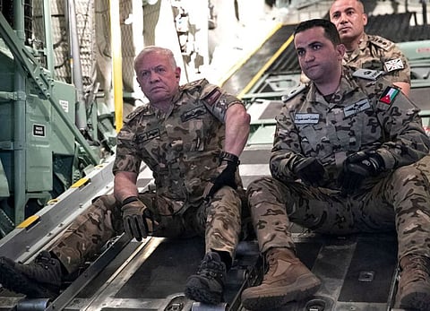 A handout picture obtained from the Jordan Public Security's facebook page on February 27, 2024 shows Jordan's King Abdullah II (left) on board a military aircraft during an operation to drop humanitarian aid over the southern Gaza Strip.