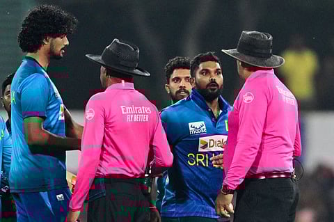Sri Lanka's captain Wanindu Hasaranga (2nd right) speaks with umpire Lyndon Hannibal during the third and final Twenty20 international cricket match against Afghanistan at the Rangiri Dambulla International Cricket Stadium on February 21.