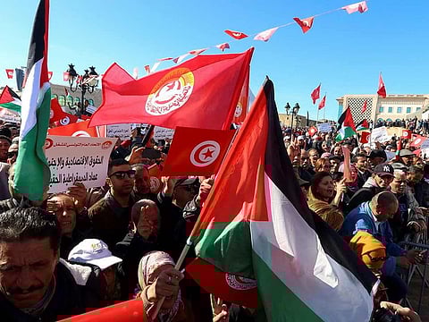 Members of the Tunisian General Labour Union (UGTT) carry banners and flags during a protest to condemn the restrictions on union rights and denounce increases in prices, near the Prime Minister's office in Tunis, on March 2, 2024.