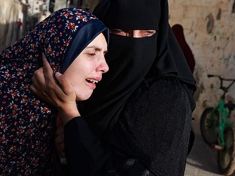 Rania Abu Anza (left), mother of twin babies Naeem and Wissam, killed in an overnight Israeli air strike, mourns their death ahead of their burial in Rafah in the southern Gaza Strip on March 3, 2024.