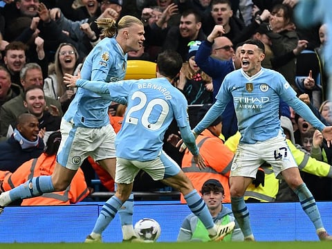 Manchester City's Erling Haaland (left) celebrates with Bernardo Silva (centre) and Phil Foden after scoring a goal.