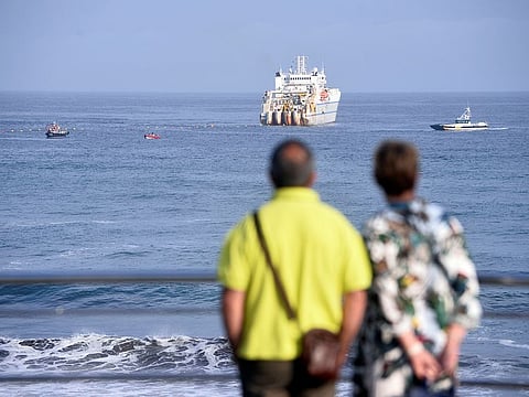 A couple observe a cable laying ship at Arrietara beach, near Bilbao, northern Spain, June 13, 2017, as Facebook Inc. and Microsoft Corp. join forces to build an underwater fiber optic cable across the Atlantic Ocean, linking Europe and the USA.