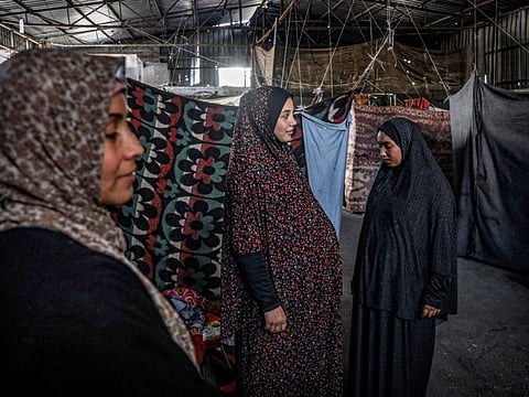 A pregnant Palestinian woman displaced from northern Gaza stands in a warehouse where she is taking shelter in Rafah, in the southern Gaza Strip, on February 29, 2024.