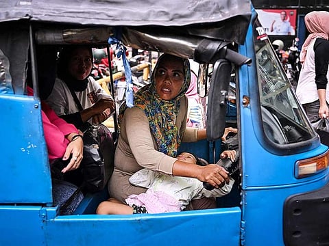 Autorickshaw driver and single mother Ekawati, who plies her three-wheeled taxi in a profession overwhelmingly dominated by men in Indonesia's capital city, transporting customers while her three-year-old daughter Debi rests on her lap while on their rounds in Jakarta.