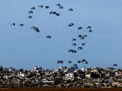 Packages fall towards northern Gaza, after being dropped from a military aircraft, amid the ongoing conflict between Israel and the Palestinian group Hamas in southern Israel March 7, 2024.