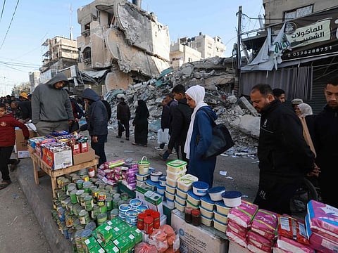 Palestinians walk past stalls set up in a street in Rafah, in the southern Gaza Strip on March 10, 2024, as Muslims prepare for Ramadan amid ongoing battles between Israel and the Palestinian militant group Hamas.