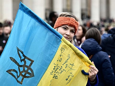 A woman holds a Ukrainian flag at St.Peter's square as Pope Francis addresses the crowd during his Sunday Angelus prayer on March 10, 2024 at the Vatican.