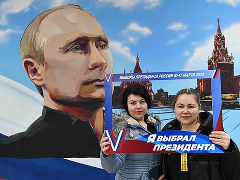 Women pose in front of a mural depicting Russian President Vladimir Putin after voting in Russia's presidential election at a polling station in a local school in Donetsk, Russian-controlled Ukraine, amid the Russia-Ukraine conflict on March 15, 2024.