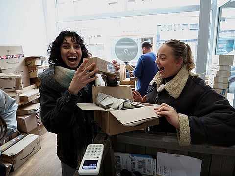 Belgian Chloe Boseret, 20, Moroccan Hiba Did, 20 and French Anouk Anglade react after opening a parcel at "Pile ou Face", a shop that sells still-sealed packages, which were lost during delivery or remained uncollected at the post office, by the kilo, without knowing their contents, in Ixelles, Brussels, Belgium.