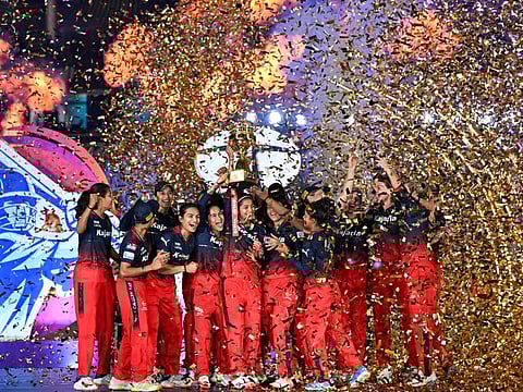 Royal Challengers Bangalore's players celebrate with the trophy after winning the Women's Premier League (WPL) Twenty20 cricket final match against Delhi Capitals at the Arun Jaitley Stadium in New Delhi on Sunday.