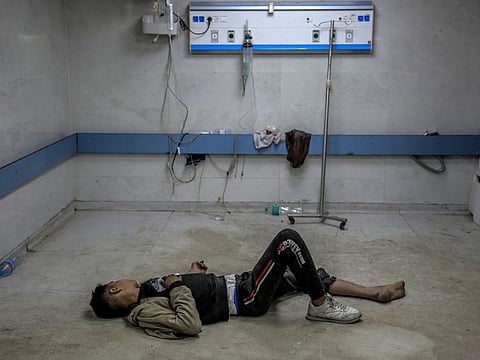 A young Palestinian injured in Israeli bombardment lies on the ground as he awaits medical attention at the Al Shifa hospital in Gaza City on March 15, 2024.