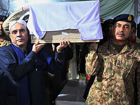 This handout photograph taken on March 17, 2024 and released by the Pakistan's Inter Service Public Relation (ISPR) shows Pakistan's Army Chief General Syed Asim Munir (right) and Pakistans President Asif Ali Zardari carrying the coffin of captain Muhammad Ahmed Badar, who was killed along with other soldiers in a militant attack in north Waziristan district, during the funeral ceremony at Chaklala garrison in Rawalpindi. Seven Pakistani soldiers and six assailants were killed on March 16 in an attack on a security post close to the border with Afghanistan, according to the military.