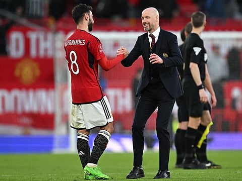 Manchester United's Portuguese midfielder #08 Bruno Fernandes (L) and Manchester United's Dutch manager Erik ten Hag (R) celebrate on the pitch after extra-time in the English FA Cup Quarter Final football match between Manchester United and Liverpool at Old Trafford in Manchester, north west England, on March 17, 2024. Manchester United won the game 4-3 after extra-time. (Photo by Paul ELLIS / AFP) / RESTRICTED TO EDITORIAL USE. No use with unauthorized audio, video, data, fixture lists, club/league logos or 'live' services. Online in-match use limited to 120 images. An additional 40 images may be used in extra time. No video emulation. Social media in-match use limited to 120 images. An additional 40 images may be used in extra time. No use in betting publications, games or single club/league/player publications. /