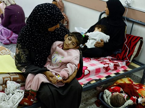 Palestinian woman Umm Mesbah Heji holds her malnourished daughter Israa, who is quadriplegic and epileptic, at Al Awda health centre in Rafah in the southern Gaza Strip, March 12, 2024.