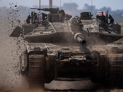Israeli soldiers drive a tank on the border with Gaza Strip, in southern Israel, on Tuesday, March 19, 2024.