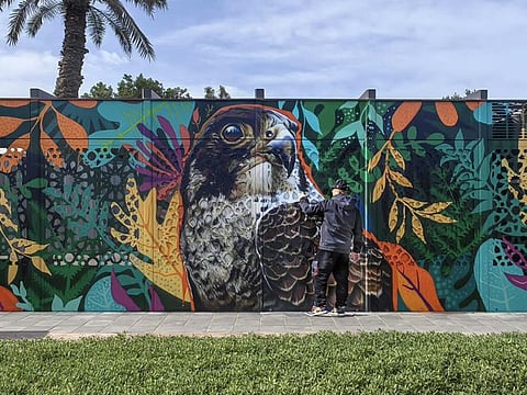 An artist works on a mural in Abu Dhabi, as part of the Abu Dhabi Canvas initiative.