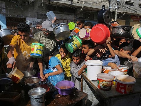 Palestinians crowd together as they wait for food distribution in Rafah, southern Gaza Strip,