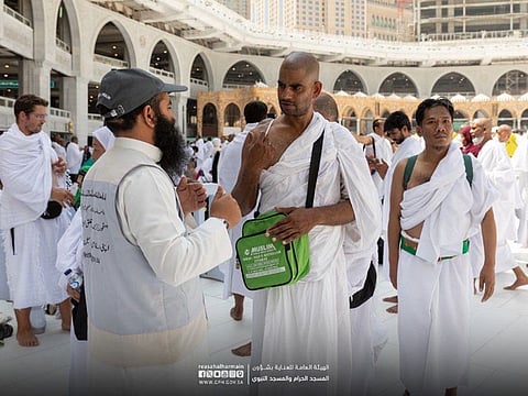 Staff at the Grand Mosque guide worshippers.