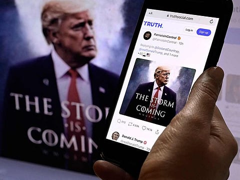 In this photo illustration, former US president Donald Trump's TRUTH Social account on a mobile device with an image of Trump in the background in Washington, DC.