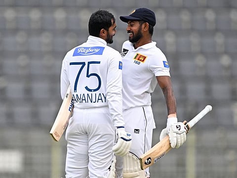 Sri Lanka's Dhananjaya de Silva (left) celebrates with Kamindu Mendis after scoring a century during the third day of the first Test cricket match against Bangladesh at the Sylhet International Cricket Stadium in Sylhet on Sunday.