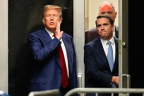 Former US President Donald Trump (left) speaks toward the press in a hallway outside the courtroom during a recess in a hearing to determine the date of his trial for allegedly covering up hush money payments linked to extramarital affairs, at Manhattan Criminal Court in New York City on March 25, 2024.