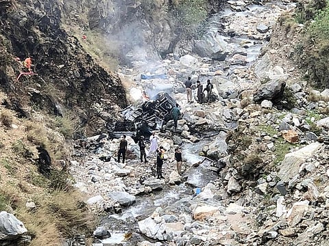 Security officials inspect the wreckage of a vehicle which was carrying Chinese engineers that plunged into a deep ravine off the mountainous Karakoram Highway after a suicide attack near Besham city in the Shangla district of Khyber Pakhtunkhwa province on March 26, 2024.