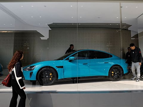 People look at Xiaomi's first electric vehicle SU7.