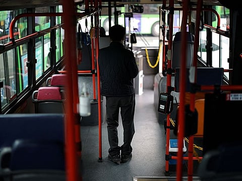 A bus driver stands inside a bus at a depot, as bus drivers go on strike, in Seoul.
