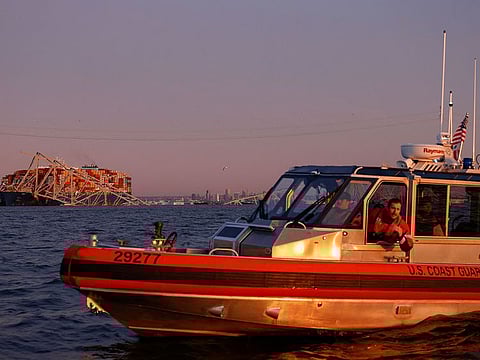 A US Coast Guard vessel secures the perimeter, after the Dali cargo vessel crashed into the Francis Scott Key Bridge causing it to collapse in Baltimore, Maryland,