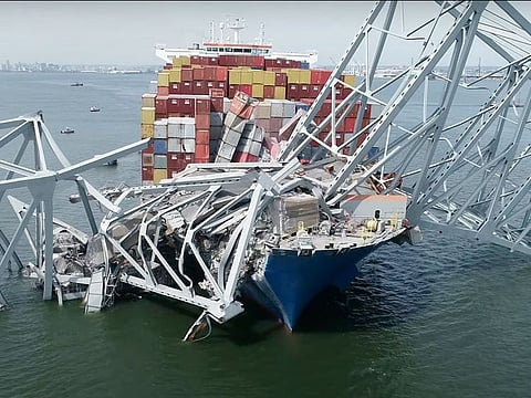 The cargo ship Dali is stuck under part of the structure of the Francis Scott Key Bridge after the ship hit the bridge.