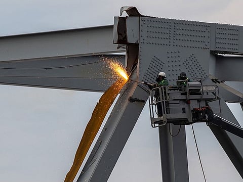 Demolition crews cutting the top portion of the north side of the collapsed Francis Scott Key Bridge into smaller sections for safe removal by crane in the Patapsco River, in Baltimore, Maryland.