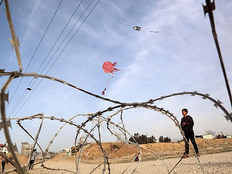 A displaced Palestinian child flies a kite near the border with Egypt in Rafah.