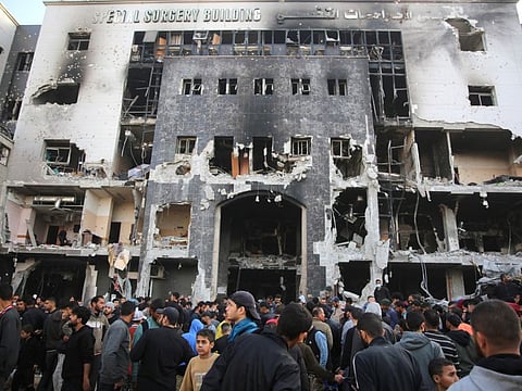 Palestinians inspect the damage outside Gaza's Al Shifa hospital after the Israeli military withdrew from the complex on April 1, 2024.