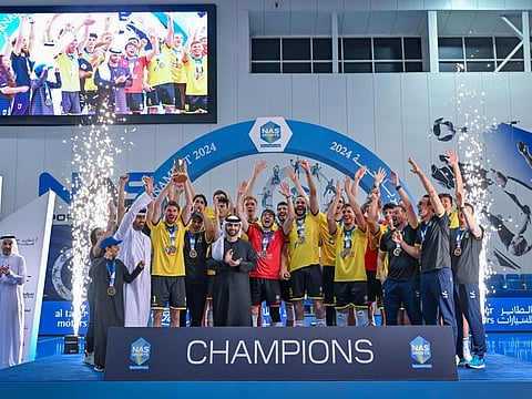 Zabeel 2 players celebrate after receiving the trophy from Sheikh Mansoor on the final day of the Nad Al Sheba Sports Tournament on Sunday.
