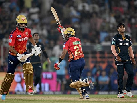 Punjab Kings' Shashank Singh and Harpreet Brar celebrate their win as Gujarat Titans' Darshan Nalkande and captain Shubman Gill watch at the end of their IPL match.
