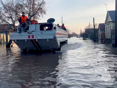 Rescuers search for residents to evacuate as they drive in a flooded residential area in the city of Orsk, Russia, on April 6, 2024.