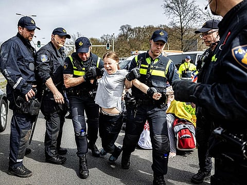 Swedish climate activist Greta Thunberg (centre) is arrested during a climate march against fossil subsidies near the highway A12 in the Hague, on April 6, 2024.
