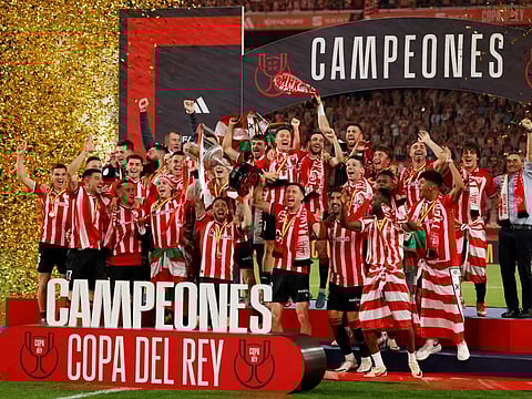 Athletic Bilbao's Iker Muniain and teammates celebrate winning the Copa del Rey with the trophy.
