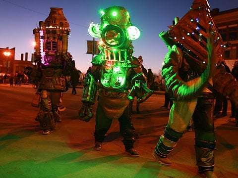People dressed as alien creatures walk through the main square during an eclipse festival on April 07, 2024, in Houlton, Maine.