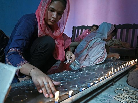 Women work on glass bangles at a home workshop in Hyderabad.
