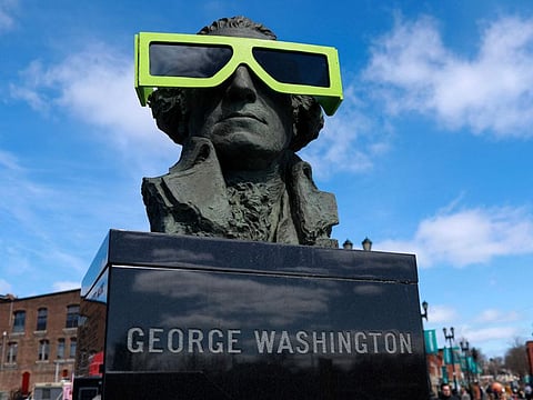 Eclipse glasses are worn by a statue of George Washington on April 07, 2024, in Houlton, Maine. Millions of people have flocked to areas across North America that are in the "path of totality" in order to experience a total solar eclipse.