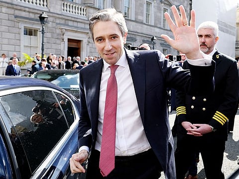 Simon Harris waving as he he leaves from Leinster House, the seat of the Irish Parliament, after being voted in as Ireland's new Prime Minister.