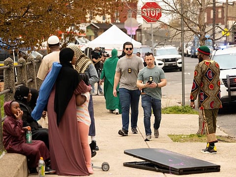 Two ATF agents walk outside Clara Mohammad Square after a shooting broke up an Eid celebration in Philadelphia, Pennsylvania, on April 10, 2024.