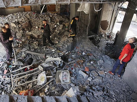 Palestinians inspect the damage to the home of the Tabatibi family after Israeli bombardment in the Daraj Neighbourhood of Gaza on April 12, 2024.