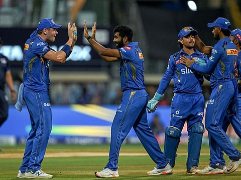 Mumbai Indians' Jasprit Bumrah celebrates with teammates after taking the wicket of Royal Challengers Bengaluru's Virat Kohli.