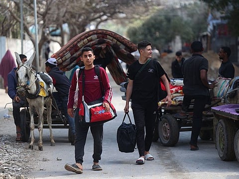 Palestinians carry belongings as people fleeing conflict leave their homes, in the Nuseirat refugee camp in central Gaza on April 12, 2024, amid the ongoing conflict between Israel and the Palestinian militant group Hamas.