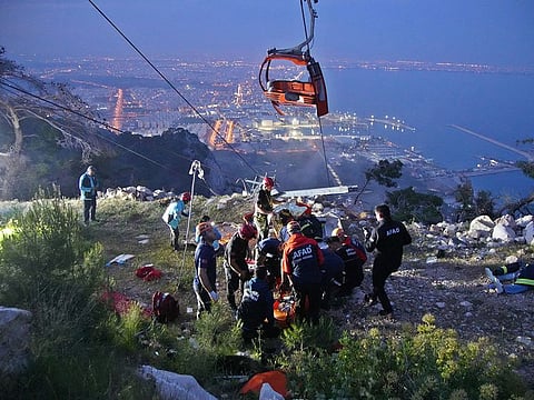 Members of Turkey's Disaster Management Authority (AFAD) take part in a rescue operation after a cable car cabin collided with a broken pole, in Antalya, Turkey.