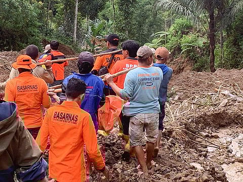 Rescuers carrying a body bag at a landslide site in Tana Toraja, South Sulawesi.
