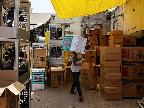 A man carries an air cooler at a market, on a hot summer day in New Delhi, India, May 23, 2023.